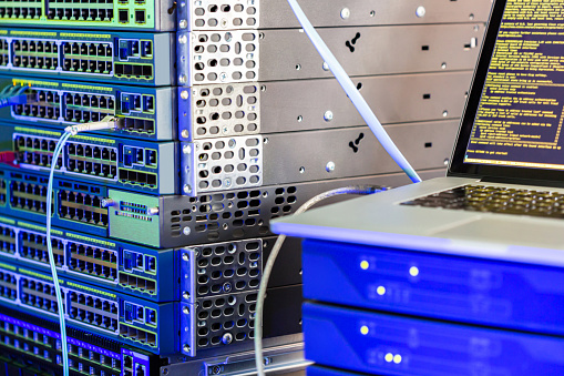 Server racks in a computer data center with interface, switch and attached communications cables in a cloud computing and IT concept